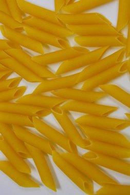 İtalyan sarısı makarna, erişte makarna, beyaz arka plana saçılmış buğday tüyü..