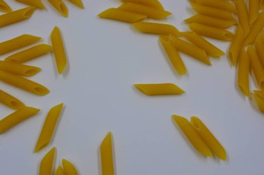 İtalyan sarısı makarna, erişte makarna, beyaz arka plana saçılmış buğday tüyü..