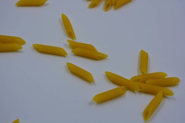 İtalyan sarısı makarna, erişte makarna, beyaz arka plana saçılmış buğday tüyü..