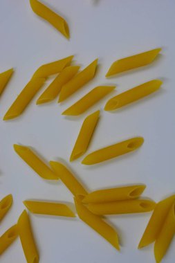 İtalyan sarısı makarna, erişte makarna, beyaz arka plana saçılmış buğday tüyü..