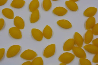 İtalyan sarı makarnası buğdaydan yapılmış, vermicelli kabukları beyaz arka plana saçılmış..