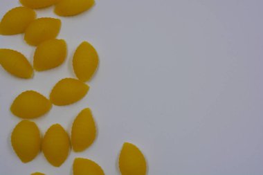 İtalyan sarı makarnası buğdaydan yapılmış, vermicelli kabukları beyaz arka plana saçılmış..