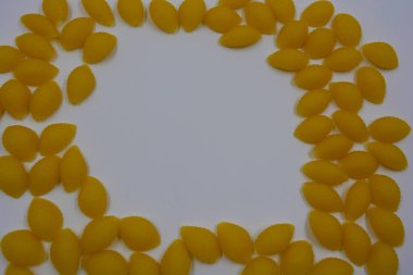 İtalyan sarı makarnası buğdaydan yapılmış, vermicelli kabukları beyaz arka plana saçılmış..