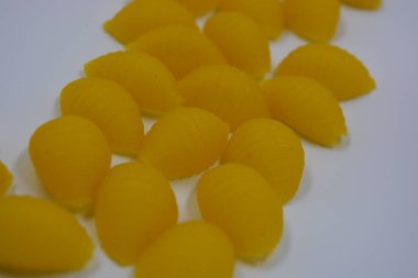 İtalyan sarı makarnası buğdaydan yapılmış, vermicelli kabukları beyaz arka plana saçılmış..