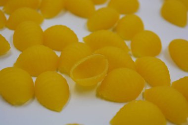 İtalyan sarı makarnası buğdaydan yapılmış, vermicelli kabukları beyaz arka plana saçılmış..