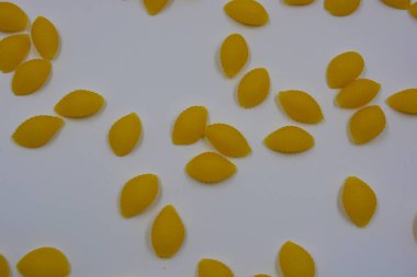 İtalyan sarı makarnası buğdaydan yapılmış, vermicelli kabukları beyaz arka plana saçılmış..