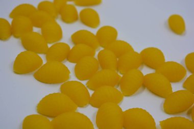 İtalyan sarı makarnası buğdaydan yapılmış, vermicelli kabukları beyaz arka plana saçılmış..