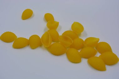 İtalyan sarı makarnası buğdaydan yapılmış, vermicelli kabukları beyaz arka plana saçılmış..