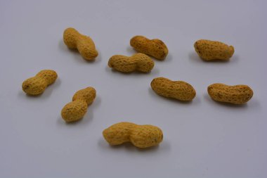 Kahverengi kabuklarındaki doğal fıstıklar beyaz arka planda yer alır..