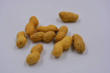 Kahverengi kabuklarındaki doğal fıstıklar beyaz arka planda yer alır..