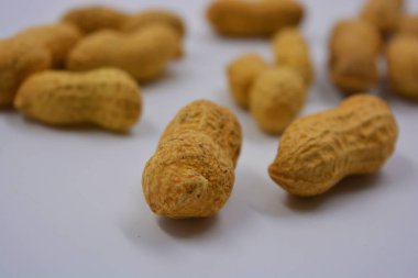 Kahverengi kabuklarındaki doğal fıstıklar beyaz arka planda yer alır..