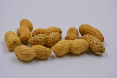 Kahverengi kabuklarındaki doğal fıstıklar beyaz arka planda yer alır..