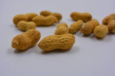 Kahverengi kabuklarındaki doğal fıstıklar beyaz arka planda yer alır..