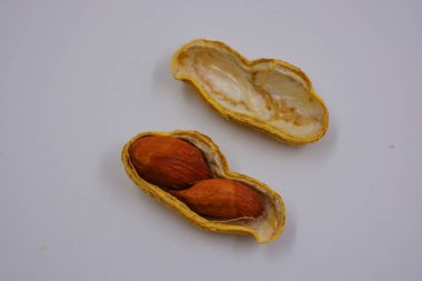 Kendi kabuklarında doğal fıstıklar, ki bu da çeşitli yollarla açılır. Fıstıklı açık kabuklar beyaz arka planda yer almaktadır..