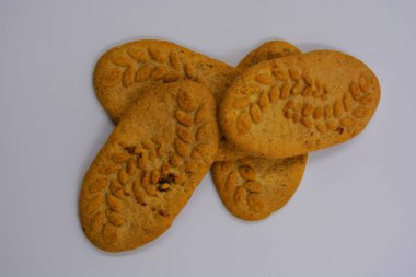 Sağlıklı, şekersiz gevrek kurabiyeleri, doğal malzemeler, fındık ve kepek içeren beyaz bir arka planda yer almaktadır..