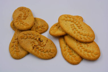 Sağlıklı, şekersiz gevrek kurabiyeleri, doğal malzemeler, fındık ve kepek içeren beyaz bir arka planda yer almaktadır..