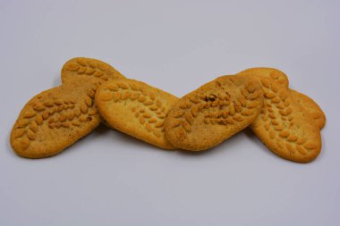 Sağlıklı, şekersiz gevrek kurabiyeleri, doğal malzemeler, fındık ve kepek içeren beyaz bir arka planda yer almaktadır..