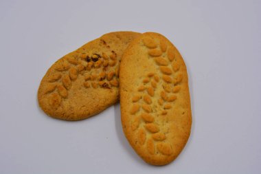 Sağlıklı, şekersiz gevrek kurabiyeleri, doğal malzemeler, fındık ve kepek içeren beyaz bir arka planda yer almaktadır..