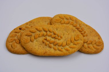 Sağlıklı, şekersiz gevrek kurabiyeleri, doğal malzemeler, fındık ve kepek içeren beyaz bir arka planda yer almaktadır..