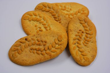 Sağlıklı, şekersiz gevrek kurabiyeleri, doğal malzemeler, fındık ve kepek içeren beyaz bir arka planda yer almaktadır..