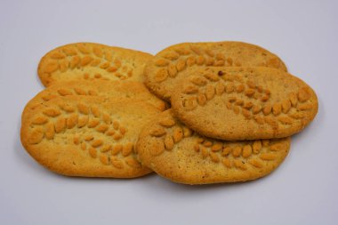 Sağlıklı, şekersiz gevrek kurabiyeleri, doğal malzemeler, fındık ve kepek içeren beyaz bir arka planda yer almaktadır..