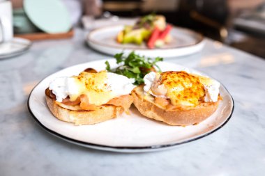 Yumurta Benedict, İngiliz çöreği somon füme ve hollandaise Sos haşlanmış bir yumurta ile tepesinde.