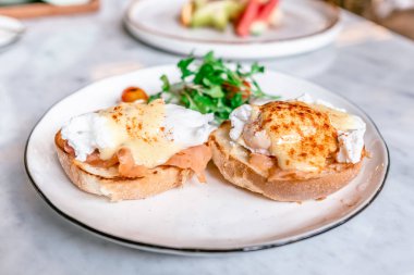 Yumurta Benedict, İngiliz çöreği somon füme ve hollandaise Sos haşlanmış bir yumurta ile tepesinde.