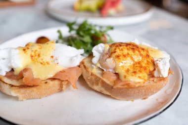 Yumurta Benedict, İngiliz çöreği somon füme ve hollandaise Sos haşlanmış bir yumurta ile tepesinde.