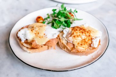 Yumurta Benedict, İngiliz çöreği somon füme ve hollandaise Sos haşlanmış bir yumurta ile tepesinde.