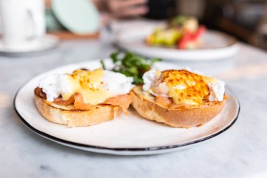 Yumurta Benedict, İngiliz çöreği somon füme ve hollandaise Sos haşlanmış bir yumurta ile tepesinde.