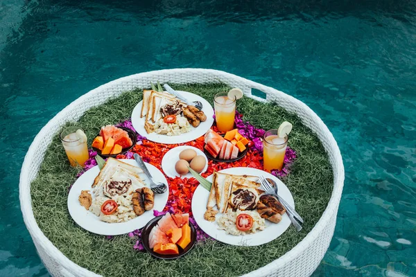 Petit déjeuner flottant dans la piscine. Petit déjeuner américain avec orange j — Photo