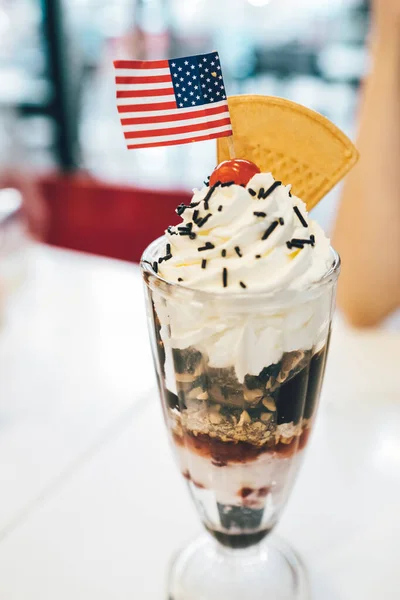 Primo piano di gelato sundae in una ciotola con salsa di fragole e — Foto Stock