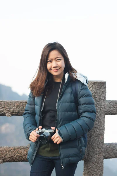 Hermosa joven asiática mujer en su invierno chaqueta, llevar cámara . — Foto de Stock
