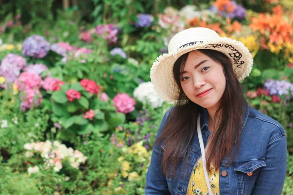 Primer plano de la joven mujer asiática con fondo de flor borrosa. — Foto de Stock