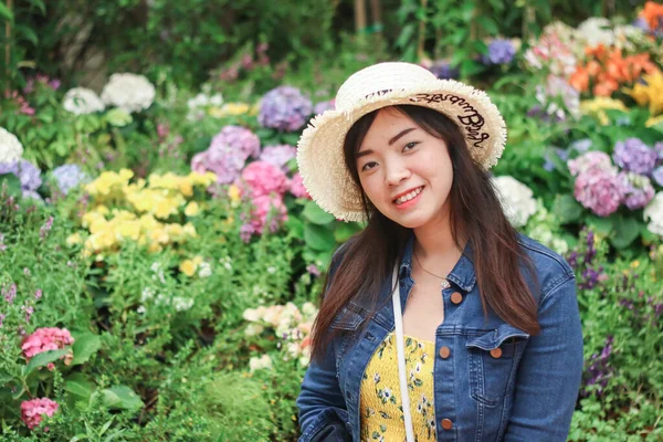 Primer plano de la joven mujer asiática con fondo de flor borrosa. —  Fotos de Stock