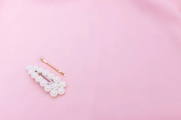 Luksusowe spinki do włosów na różowym materiale z przestrzenią do kopiowania. — Zdjęcie stockowe