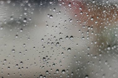 Kırmızı bokeh ışığıyla bulanık yağmurlu pencere