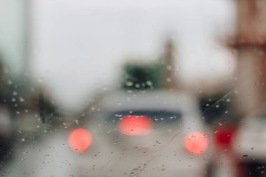 Kırmızı bokeh ışığıyla bulanık yağmurlu pencere
