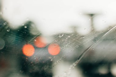 Kırmızı bokeh ışığıyla bulanık yağmurlu pencere