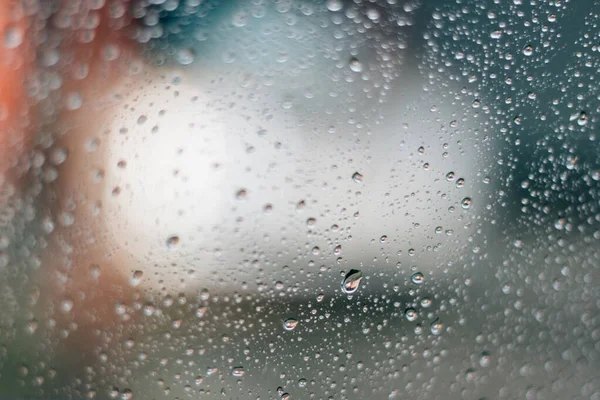 Verschwommenes Regenfenster mit rotem Bokeh-Licht — Stockfoto