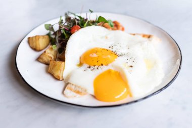 İki kızarmış yumurta, fasulye ve sala ile nefis İngiliz kahvaltısı.