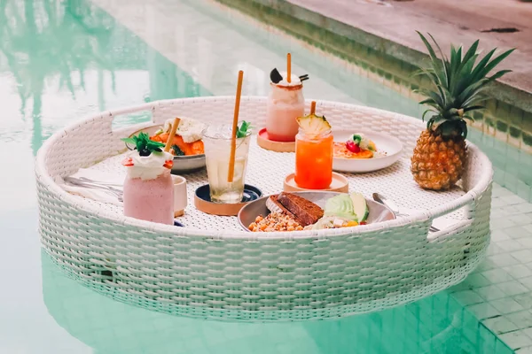 Petit déjeuner sur table flottante dans la piscine. Alimentation saine avec smoot — Photo