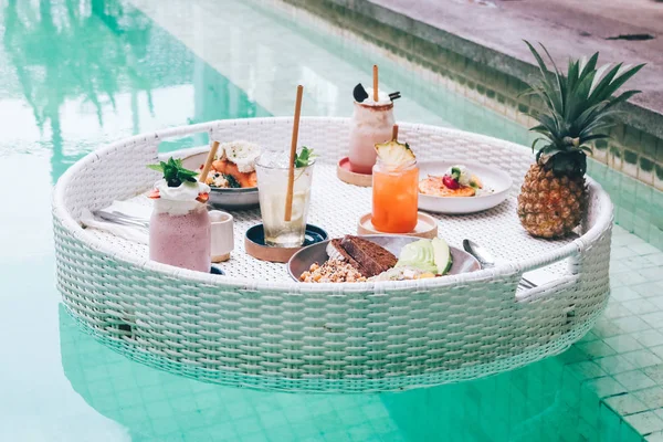 Śniadanie na pływającym stole w basenie. Zdrowa żywność z smoot — Zdjęcie stockowe