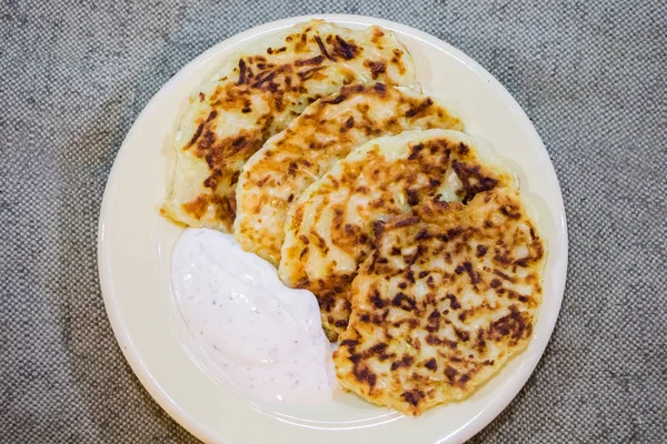 Zucchini pancakes with cream sauce from sour cream