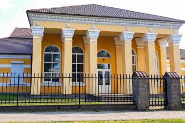 Sütunlu yenilenmiş tarihi bir bina. Güneşli bir günde eski malikane.