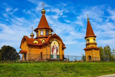 Yeşil ağaçların arasında altın kubbeleri olan güzel Hıristiyan kilisesi. Güneşli bir yaz gününde kilise binası.