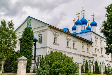 Yeşil ağaçların arasında altın kubbeleri olan güzel Hıristiyan kilisesi. Güneşli bir yaz gününde kilise binası.