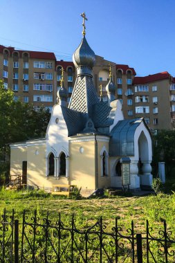 Yeşil ağaçların arasında altın kubbeleri olan güzel Hıristiyan kilisesi. Güneşli bir yaz gününde kilise binası.