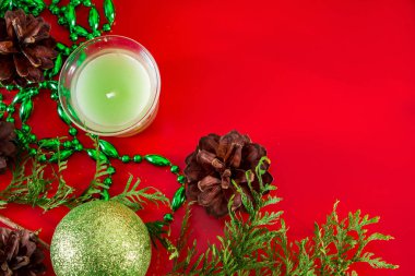 Tasarım ve tebrik kartları için kırmızı arka planda koni ve Noel toplarının şenlikli kompozisyonu. Metin için yer.