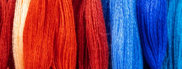 Set of multi-colored threads for embroidery. Background for design, banner format.